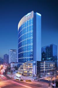 a tall glass building with a street in front of it at Amara Signature Shanghai in Shanghai