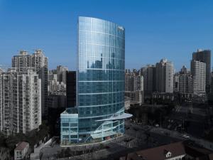 un grand bâtiment en verre au milieu d'une ville dans l'établissement Amara Signature Shanghai, à Shanghai