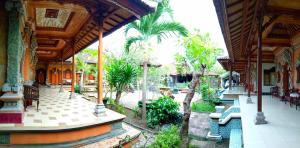a building with benches and trees in a courtyard at Ray homestay in Nusa Penida