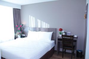 1 dormitorio con 1 cama y escritorio con silla en KL Hotel en Labuan