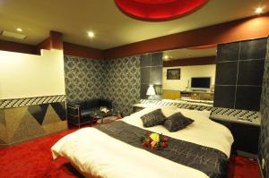 a bedroom with a large bed with flowers on it at Hotel Joyplus (Love Hotel) in Onga