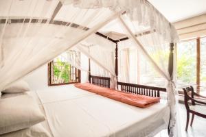 a bedroom with a canopy bed with a window at Mount Lodge Boutique Hotel in Mount Lavinia