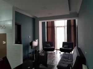 - un salon avec un canapé et deux chaises dans l'établissement Apartment in Snow Plaza 49, à Bakuriani