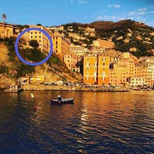 a boat in the water in front of a city at Al Piccolo Scoglio - Room & Breakfast in Camogli