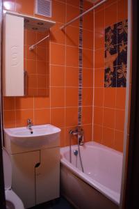 ニジネヴァルトフスクにあるПроспект Победы 10аのオレンジ色のバスルーム(シンク、バスタブ、トイレ付)