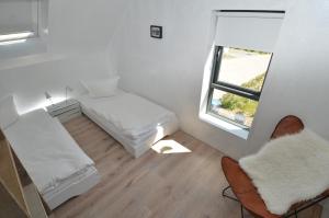ガガーにあるThe Strandwood House in Gagerのベッド2台と窓が備わる小さな客室です。