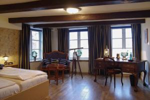 a bedroom with a bed and a desk and a chair at Hotel Restaurant Anno 1617 in Glückstadt