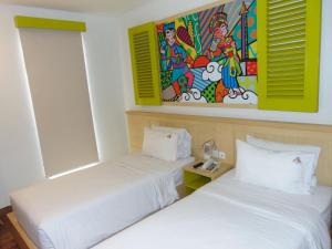 une chambre d'hôtel avec 2 lits et un tableau mural dans l'établissement MaxoneHotels.com at Kramat, à Jakarta