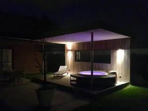 a night view of a hot tub in a backyard at Dream house in Poperinge +2 photos