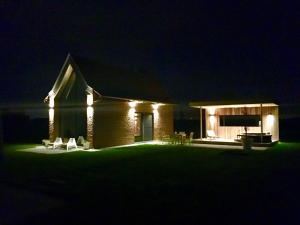 a house with lights on it at night at Dream house in Poperinge