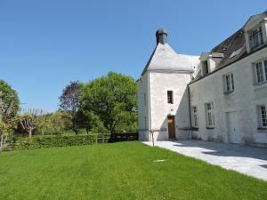 a large white building with a grass yard in front of it at Escapade in Mareuil-sur-Cher