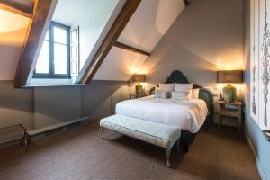 a bedroom with a large bed and a window at Domaine de Rymska & Spa - Relais & Châteaux in Saint-Jean-de-Trézy +24 photos
