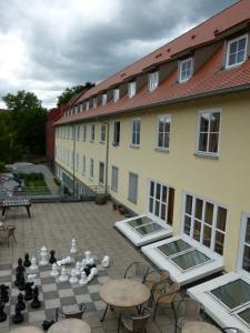 un patio con tablero de ajedrez, mesas y edificios en Jugendherberge Tübingen en Tübingen