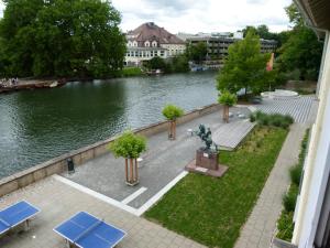 a park bench next to a river with plants growing on it at Jugendherberge Tübingen in Tübingen