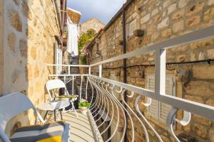 Un balcón con sillas y mesas en un edificio en Holiday Home Nada, en Dubrovnik