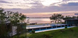 a large swimming pool next to a body of water at Baan Rim Ao in Chanthaburi