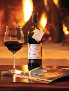 una bottiglia di vino seduta accanto a un bicchiere di vino di Podere Soccorso a Montalcino