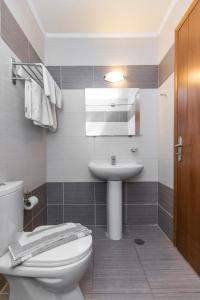 a bathroom with a white toilet and a sink at Alea Hotel Apartments in Ialysos