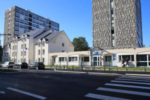 a building on the side of a street with two tall buildings at Ibis Budget Boulogne-Sur-Mer Centre les Ports in Boulogne-sur-Mer