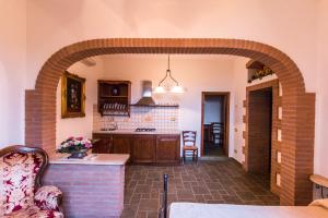 a kitchen with an archway and a table in a room at Agriturismo Villa Isa in Follonica