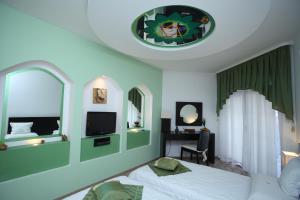 a bedroom with a bed and a window and a tv at Familly Art Hotel Nirvana in Shumen