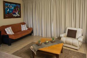 a living room with a couch and a coffee table at Island View f5 in Melkbosstrand