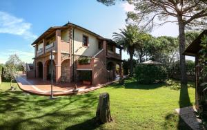 a house with a green yard with a tree at Agriturismo Villa Isa in Follonica