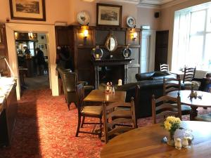 a restaurant with tables and chairs and a fireplace at The Abbey Inn in Buckfastleigh