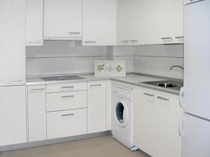 une cuisine blanche avec une machine à laver à l'intérieur dans l'établissement Apartamentos Doña Carmen, à Malaga