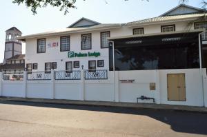 a white building with a fence in front of it at Palace Lodge Morningside in Durban