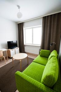a living room with a green couch and a table at Töölö Towers in Helsinki