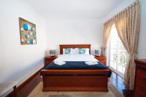 a bedroom with a bed and a large window at Grace Villa in Aldeia de Juso