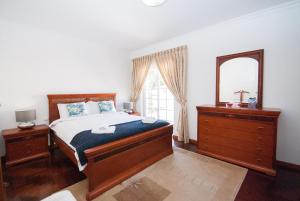 a bedroom with a bed and a mirror and a dresser at Grace Villa in Aldeia de Juso