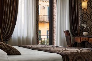 um quarto de hotel com uma cama e uma janela em Hotel Tre Archi em Veneza