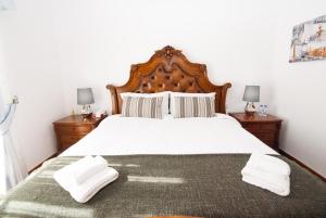 a bedroom with a large bed with two towels on it at Grace Villa in Aldeia de Juso