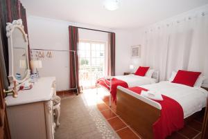 a hotel room with two beds and a mirror at Grace Villa in Aldeia de Juso