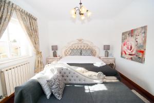 a bedroom with a white bed and a chandelier at Grace Villa in Aldeia de Juso