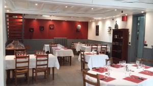a dining room with white tables and wooden chairs at Le Saintongeais in Berneuil