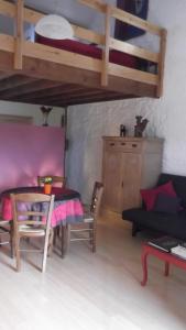 salon ze stołem i łóżkiem piętrowym w obiekcie Ferme du Pont de Bois - Le Fenil w mieście Thuin