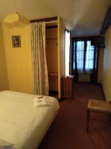 a hotel room with a bed and a window at Le Saintongeais in Berneuil