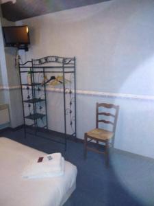 um quarto com uma cama e uma cadeira de madeira em Le Saintongeais em Berneuil