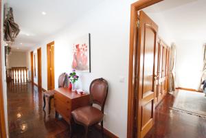 a hallway with two chairs and a desk in a house at Grace Villa in Aldeia de Juso