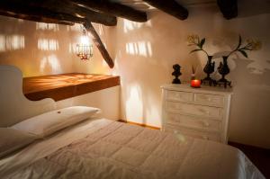 a bedroom with a white bed and a dresser at Camidù Boutique House in Palermo