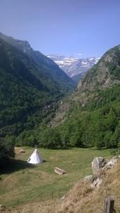 ein weißes Zelt auf einem Feld mit Bergen im Hintergrund in der Unterkunft Tipis nature in Gavarnie