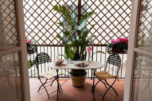 a table with chairs and a potted plant on a porch at Camidù Boutique House in Palermo