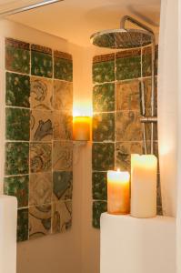 a bathroom with two candles and a wall with tiles at Camidù Boutique House in Palermo +36 photos
