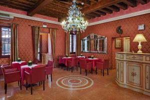 een eetkamer met tafels en stoelen en een kroonluchter bij Hotel Tre Archi in Venetië