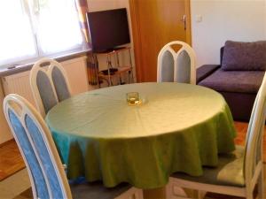 uma mesa com uma toalha de mesa verde com cadeiras em Ferienwohnung Geratal em Erfurt
