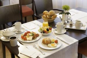 a table with plates of breakfast food on it at Sunday Hotel Hannover in Hannover +30 photos