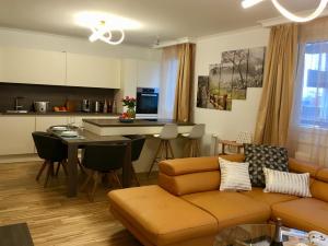 a living room with a couch and a table and a kitchen at Ferienwohnung am Hauptbahnhof in Vienna